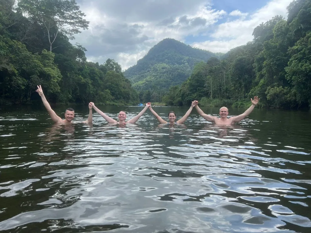 Guests enjoying a swim in a scenic Sri Lankan river